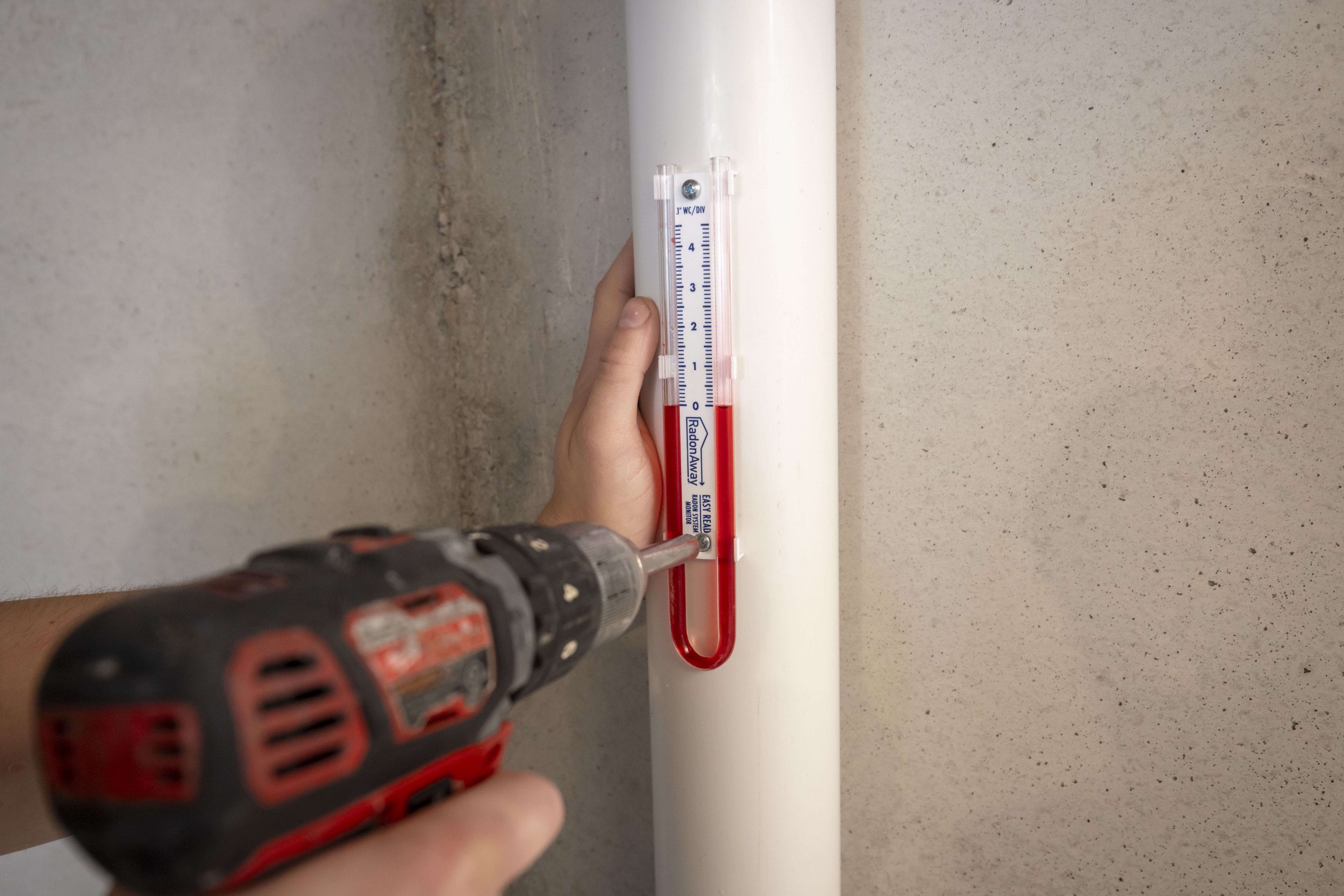 Someone screwing in a radon measuring tool.