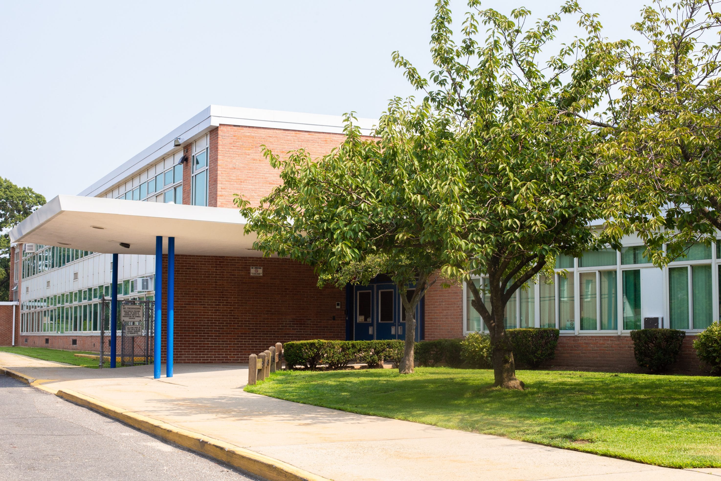 An exterior picture of a large school building with trees in front.
