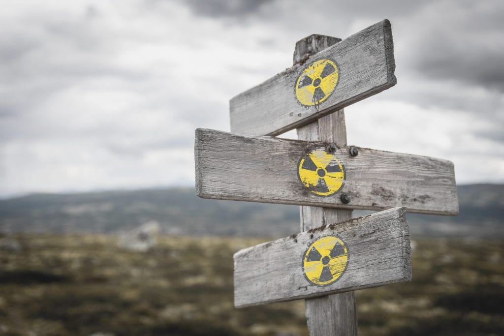 A wooden sign with three markers, all containing a radon symbol.